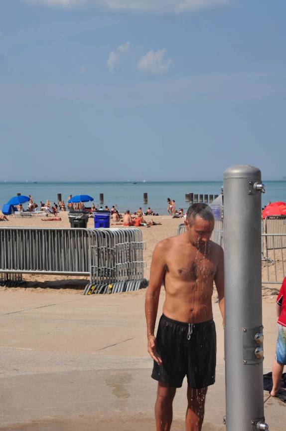 Banho de chuveiro para afastar o calor em praia de Chicago, estado de Illinois, nos Estados Unidos
